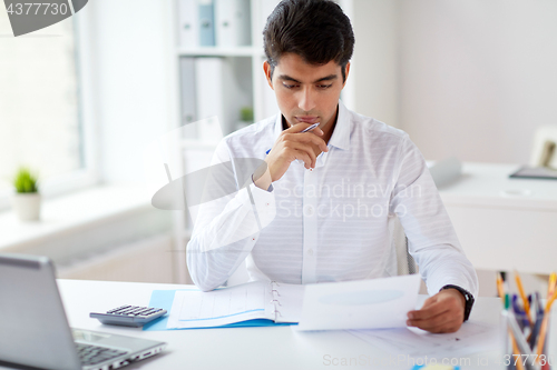 Image of businessman working with papers at office