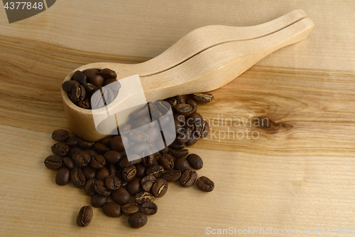 Image of coffee measuring spoon and coffee beans on a wooden board