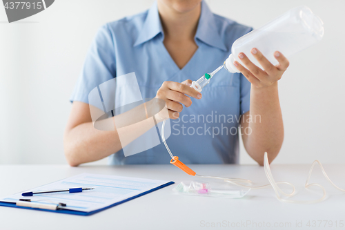 Image of close up of nurse preparing drop counter