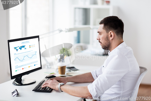 Image of businessman with charts on computer at office