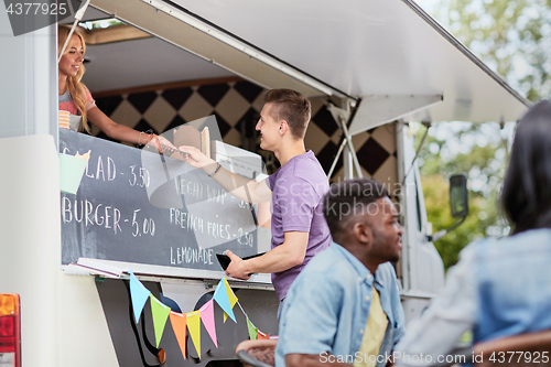 Image of customer paying money to saleswoman at food truck