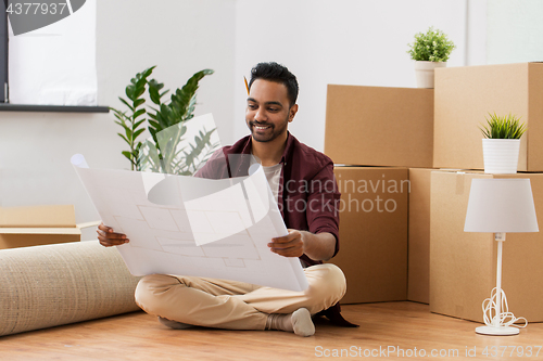 Image of man with blueprint and boxes moving to new home