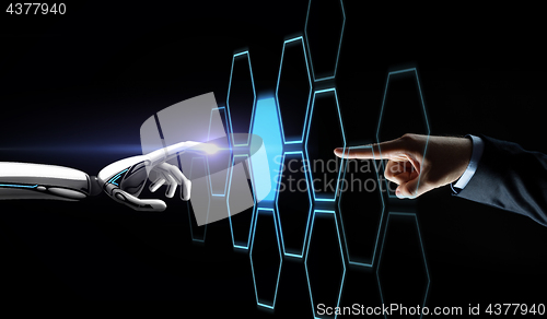 Image of robot and human hand touching network hologram