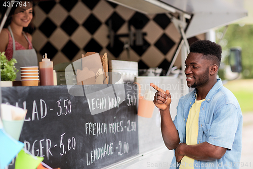 Image of male customer looking at billboard at food truck