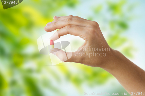 Image of close up of hand holding capsule of medicine