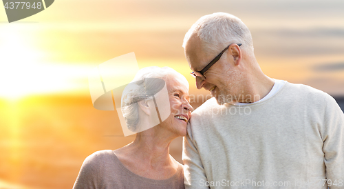 Image of happy senior couple over sunset background