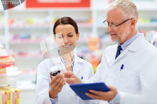 Image of apothecaries with tablet pc and drug at pharmacy