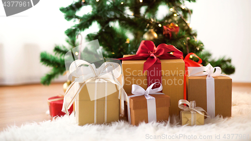 Image of gift boxes on sheepskin at christmas tree