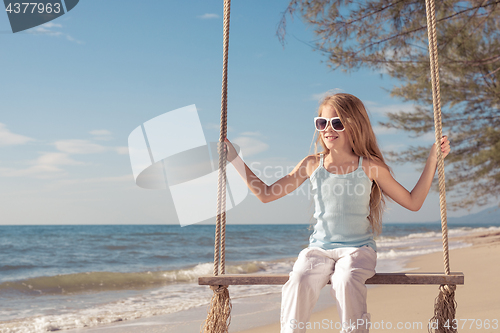 Image of One happy little girl playing on the beach at the day time.