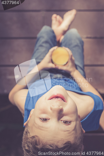 Image of one boy is sitting with a glass of juice