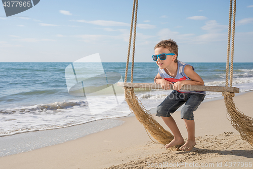 Image of One happy little boy playing on the beach at the day time.