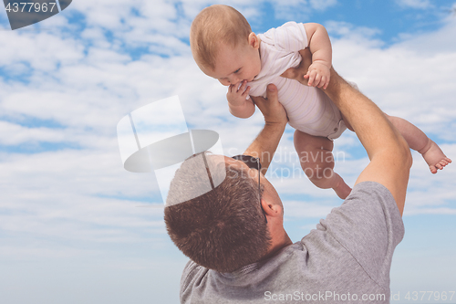 Image of Father and son playing on the beach at the day time.