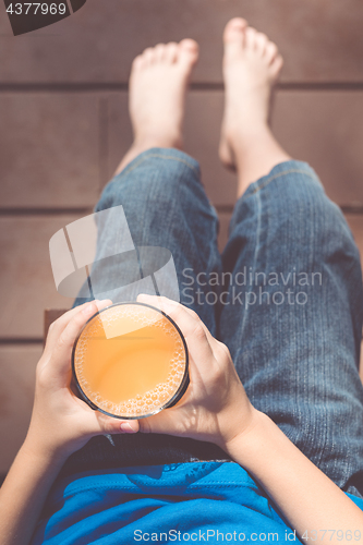 Image of one boy is sitting with a glass of juice