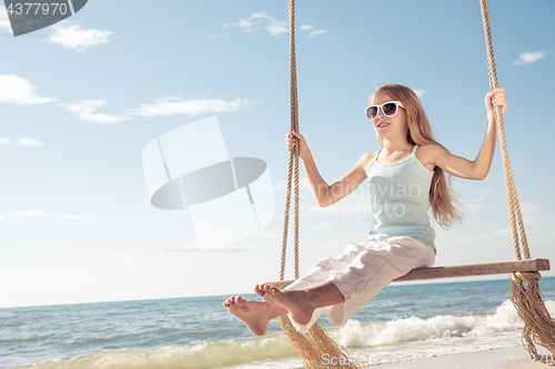 Image of One happy little girl playing on the beach at the day time.