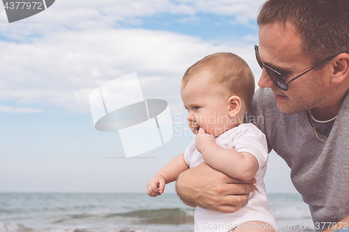 Image of Father and son playing on the beach at the day time.