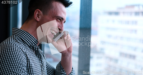 Image of Business Man Talking On Cell Phone, Looking Out Office Window