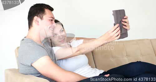 Image of Young Couple using digital tablet at home