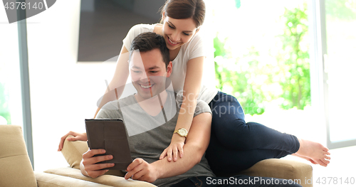 Image of Young Couple using digital tablet at home