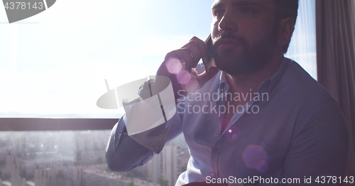 Image of Business Man Talking On Cell Phone At Home