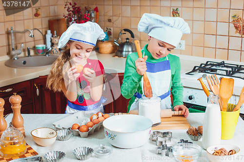 Image of happy family funny kids are preparing the dough, bake cookies in the kitchen