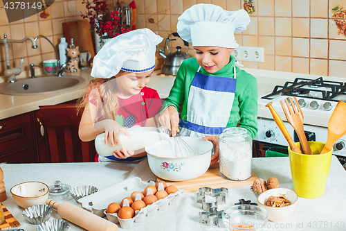 Image of happy family funny kids are preparing the dough, bake cookies in the kitchen