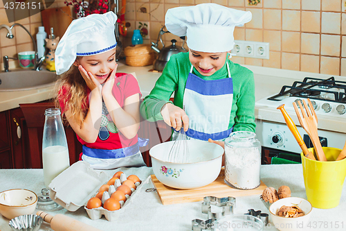 Image of happy family funny kids are preparing the dough, bake cookies in the kitchen