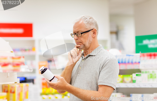 Image of senior male customer with drug at pharmacy