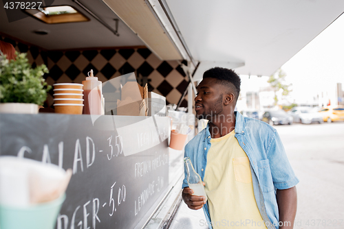 Image of african american man with drink at food truck
