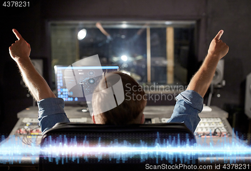 Image of man at mixing console in music recording studio