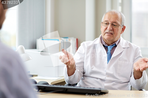 Image of senior doctor talking to male patient at hospital