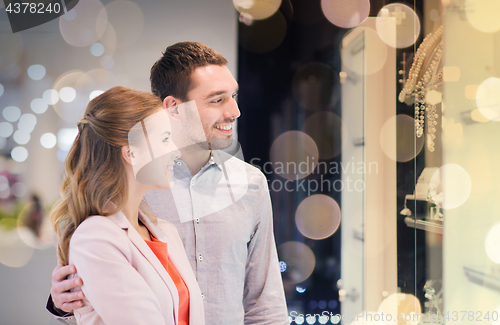 Image of couple looking to shopping window at jewelry store