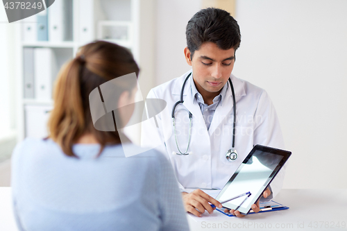 Image of doctor showing tablet pc to patient at clinic