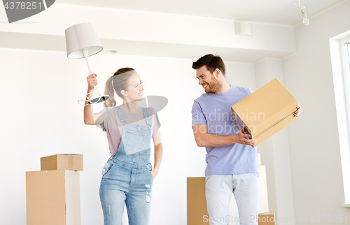 Image of couple with boxes and lamp moving to new home