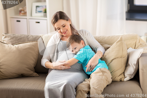 Image of happy pregnant mother and son hugging at home