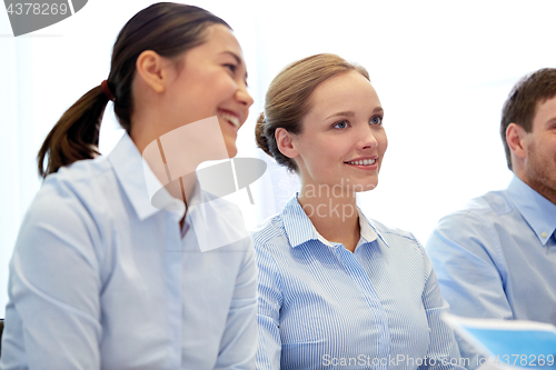 Image of group of smiling businesspeople meeting in office