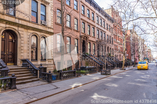 Image of Scenic tree lined street of historic brownstone buildings in the West Village neighborhood of Manhattan in New York City, NYC USA