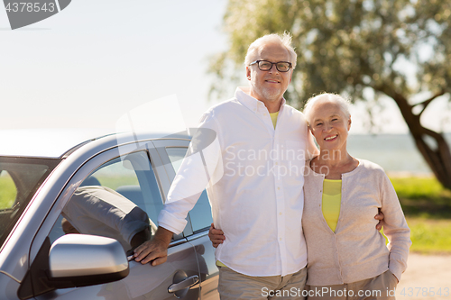 Image of happy senior couple with car in summer