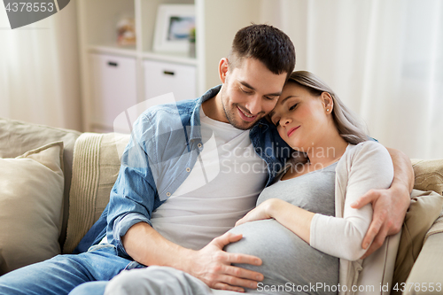 Image of man hugging pregnant woman at home