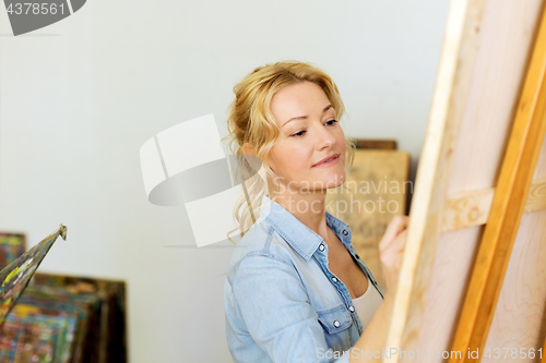 Image of woman with easel drawing at art school studio