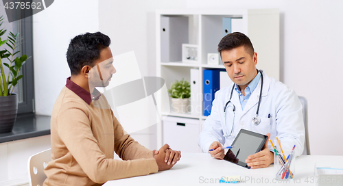 Image of doctor with tablet pc and male patient at hospital