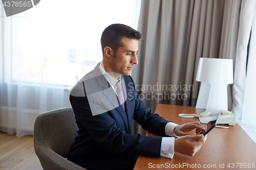 Image of businessman with tablet pc working at hotel room