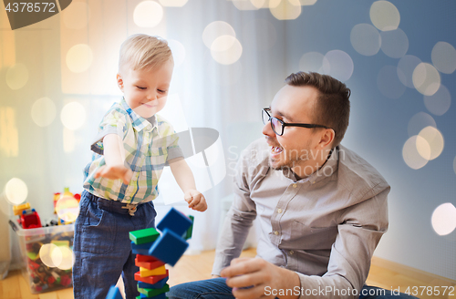 Image of father and son playing with toy blocks at home