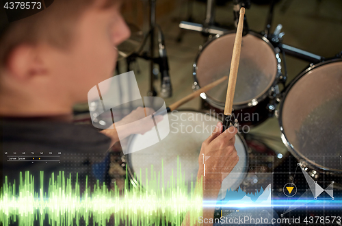 Image of male musician playing drum kit at concert