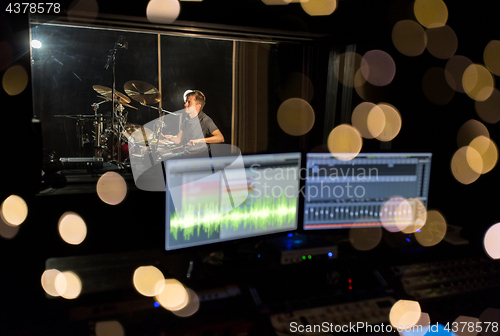 Image of man playing drum kit at sound recording studio