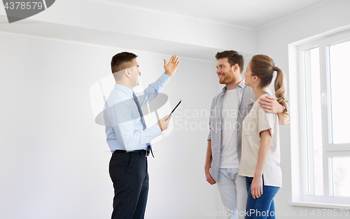 Image of couple and realtor with tablet pc at new home