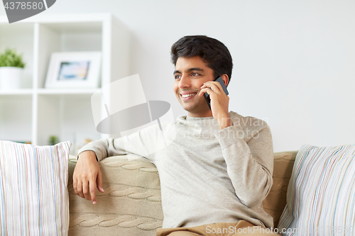 Image of happy man calling on smartphone at home