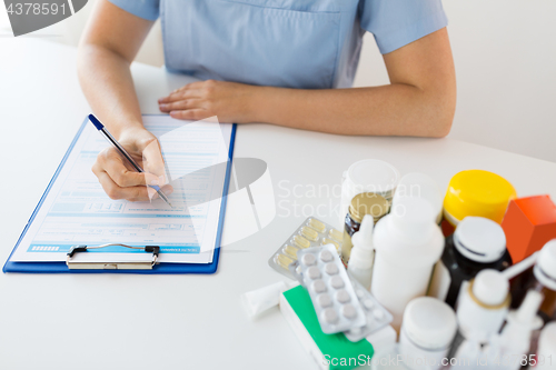 Image of doctor with medicines and clipboard at hospital