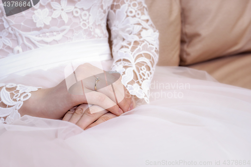 Image of Hands of the bride in white and pink wedding dress