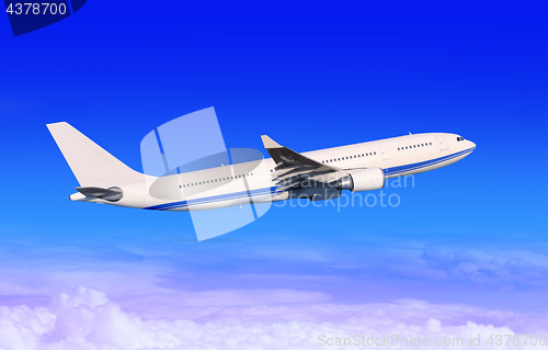Image of white passenger aircraft in blue sky 
