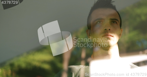 Image of reflection of sad man looking through window